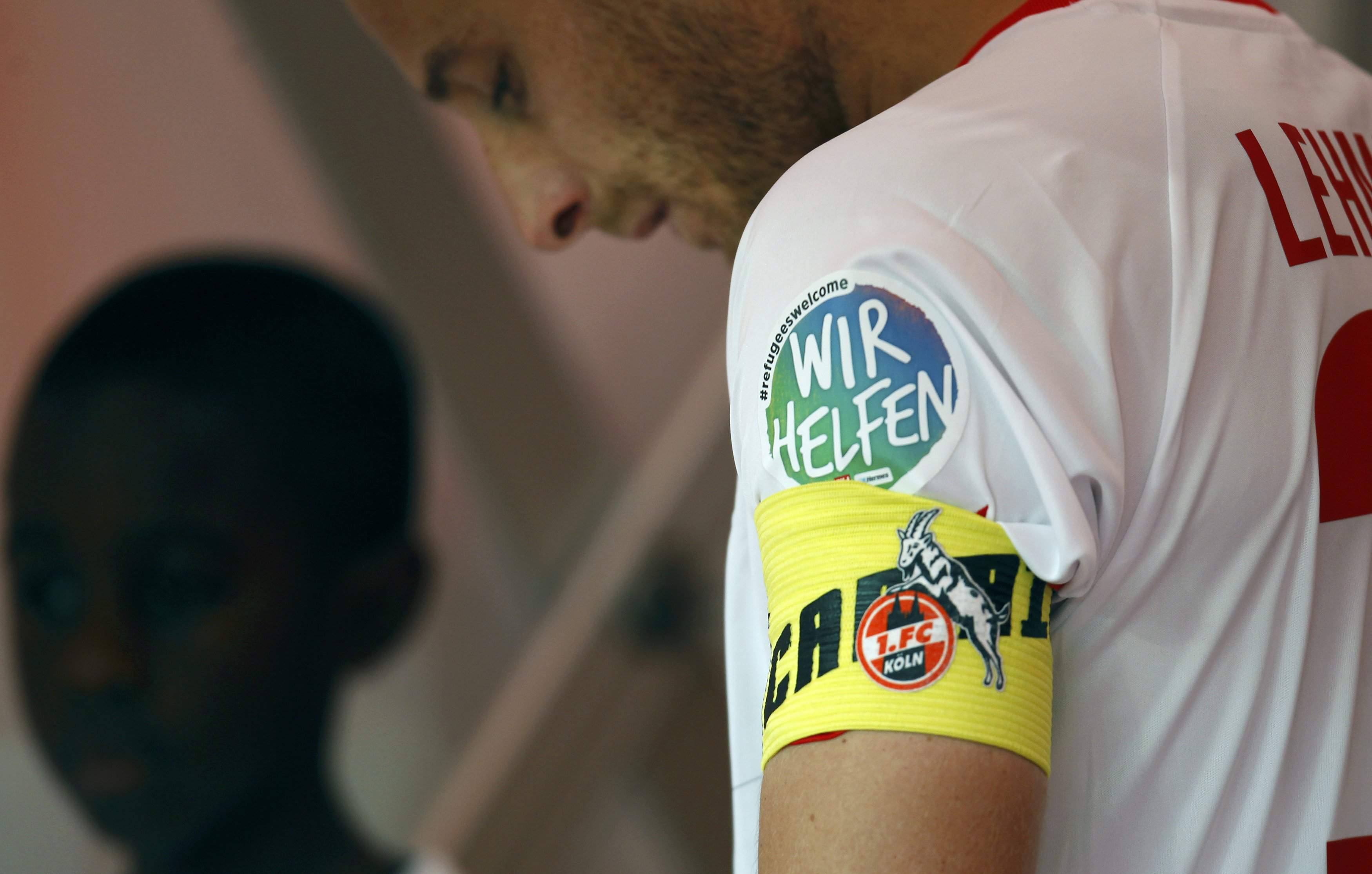 A sticker reading 'Refugees welcome. We help' is seen at the jersey of 1.FC Cologne's Matthias Lehmann during their Bundesliga first division soccer match against Borussia Moenchengladbach in Cologne, Germany September 19, 2015.  REUTERS/Ina Fassbender   DFL RULES TO LIMIT THE ONLINE USAGE DURING MATCH TIME TO 15 PICTURES PER GAME. IMAGE SEQUENCES TO SIMULATE VIDEO IS NOT ALLOWED AT ANY TIME. FOR FURTHER QUERIES PLEASE CONTACT DFL DIRECTLY AT + 49 69 650050
