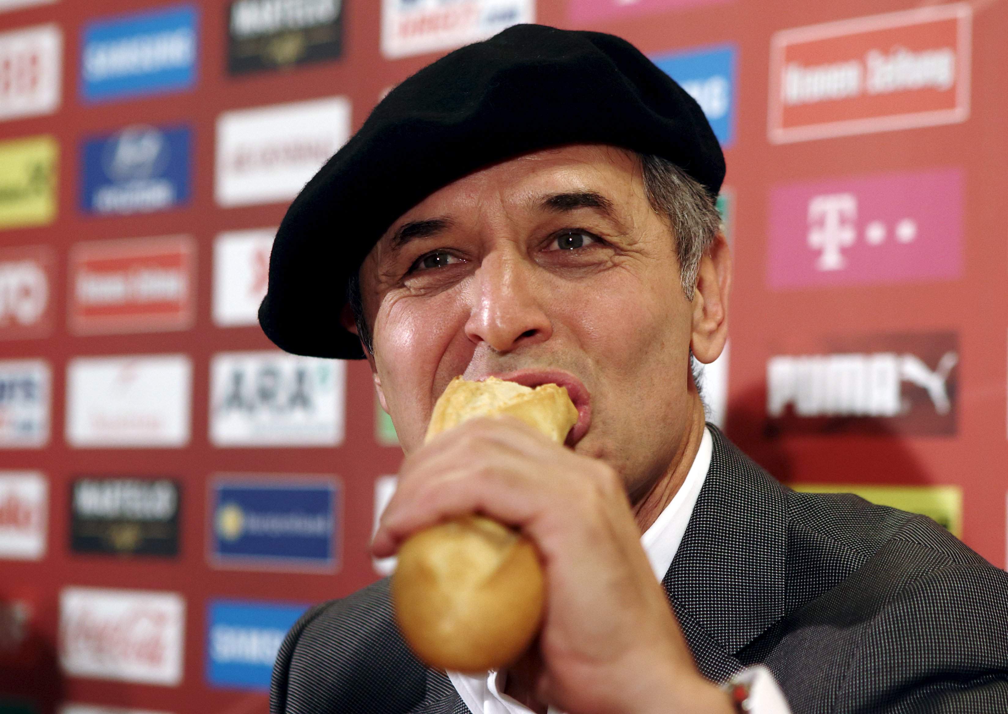 Austrian national soccer team coach Marcel Koller eats French bread during a news conference after the team qualified for the UEFA Euro 2016 in Vienna, Austria, September 9, 2015. REUTERS/Heinz-Peter Bader
