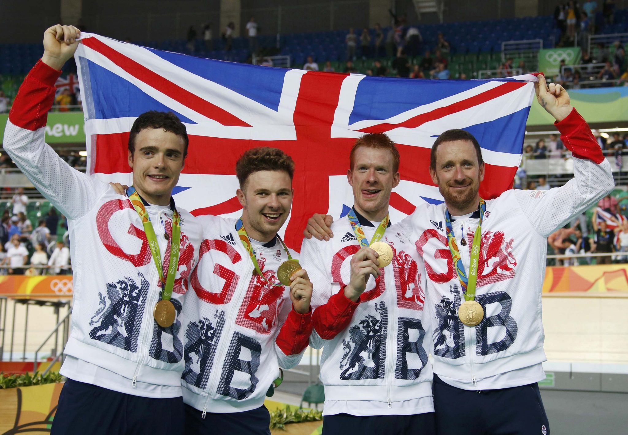 2016 Rio Olympics - Cycling Track - Victory Ceremony - Men's Team Pursuit Victory Ceremony - Rio Olympic Velodrome - Rio de Janeiro, Brazil - 12/08/2016. Steven Burke (GBR) of Britain, Owain Doull (GBR) of Britain, Ed Clancy (GBR) of Britain and Bradley Wiggins (GBR) of Britain pose with the gold medal and their country's flag. REUTERS/Eric Gaillard FOR EDITORIAL USE ONLY. NOT FOR SALE FOR MARKETING OR ADVERTISING CAMPAIGNS.